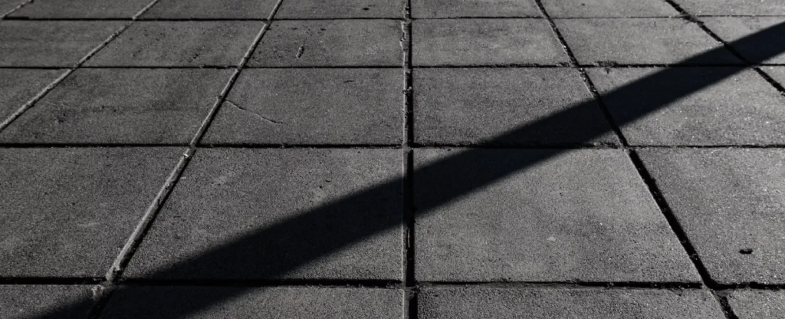 a shadow of a person on a brick surface