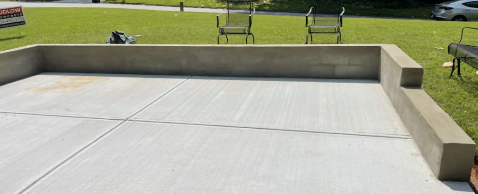 a concrete area with benches and grass