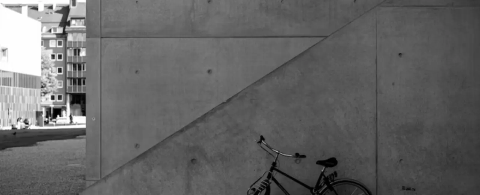 a bicycle parked next to a concrete wall