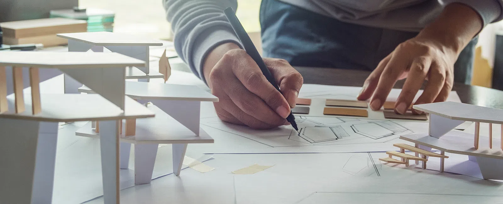 Architect working on a project with a black pen.