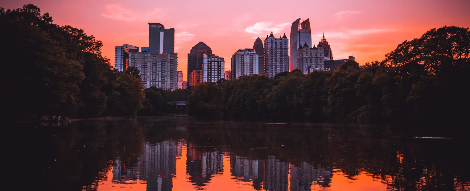 a city skyline with trees and water