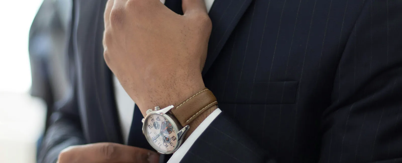 a man in a suit and tie holding his hands together