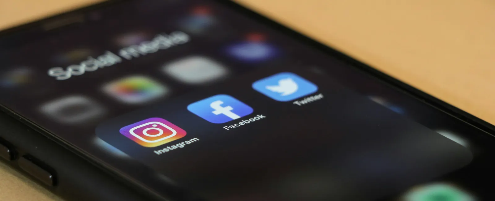 Smartphone screen showing Instagram, Facebook, and Twitter apps in a social media folder.