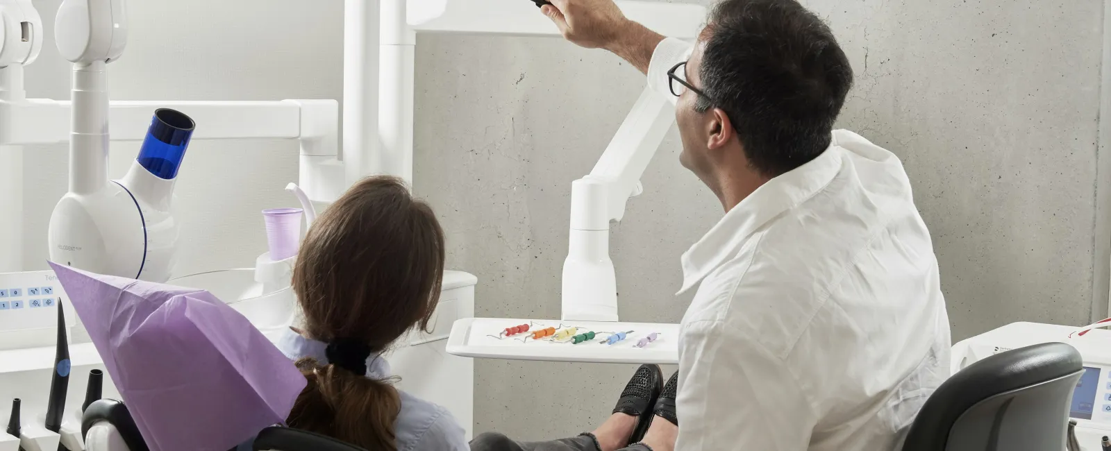 Dentist showing a dental x-ray image to a patient in a modern dental office.