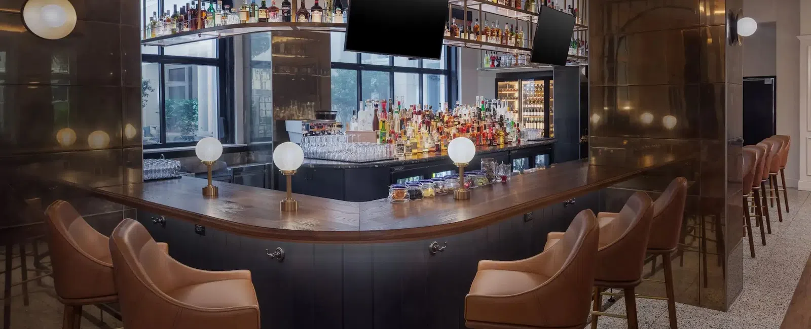 The Lowline by Hyatt JDV Hotel Custom Bar Millwork, Suspended Metal-and-Glass Liquor Shelving, Decorative Metal Focal Walls, and Island Quartz Countertop