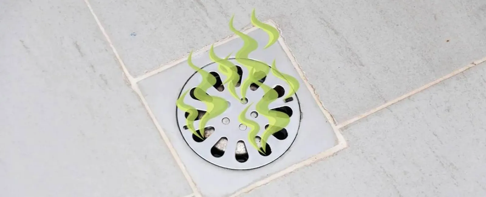 Metal drain cover on tiled floor with green odor lines indicating a bad smell or blockage issue.