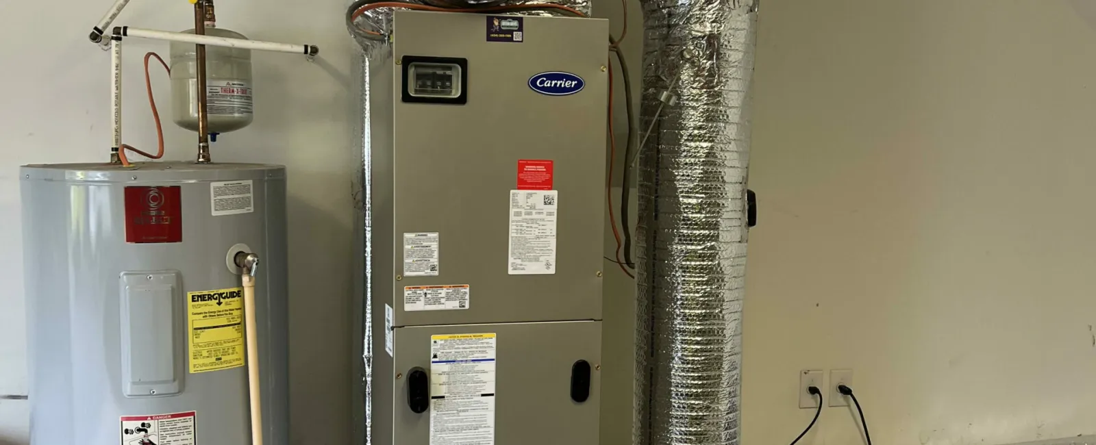 Home HVAC furnace and water heater system with insulated ductwork installed in a garage space.