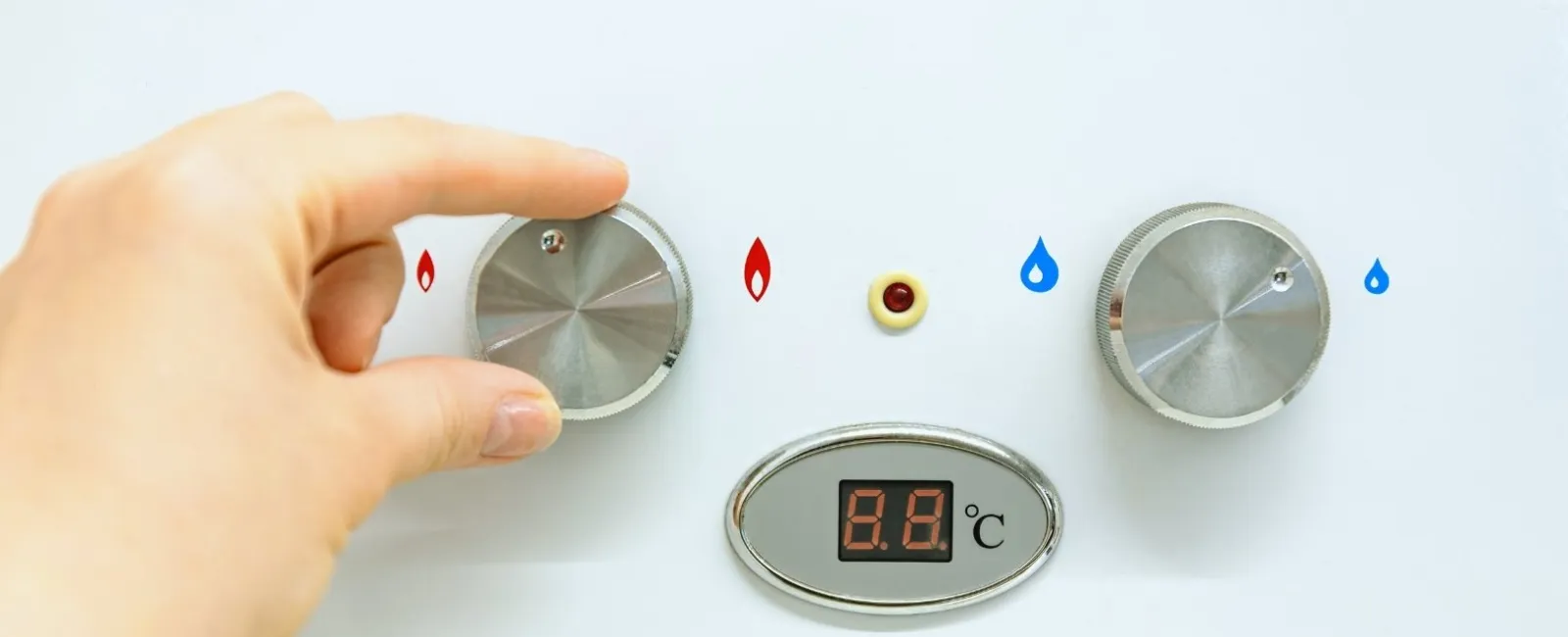 Hand adjusting temperature control knob on water heater with digital temperature display showing 8.8°C.