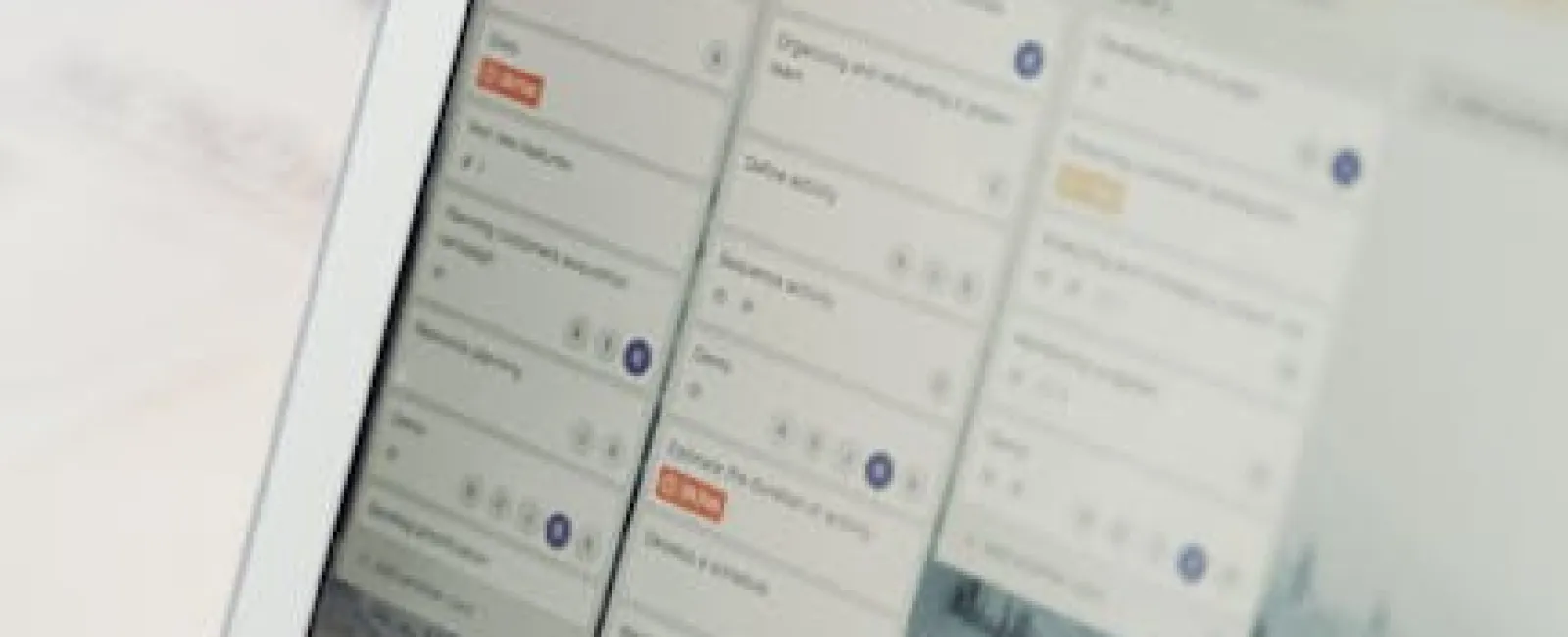 Open laptop displaying a project management or task organization dashboard with multiple task columns and cards.