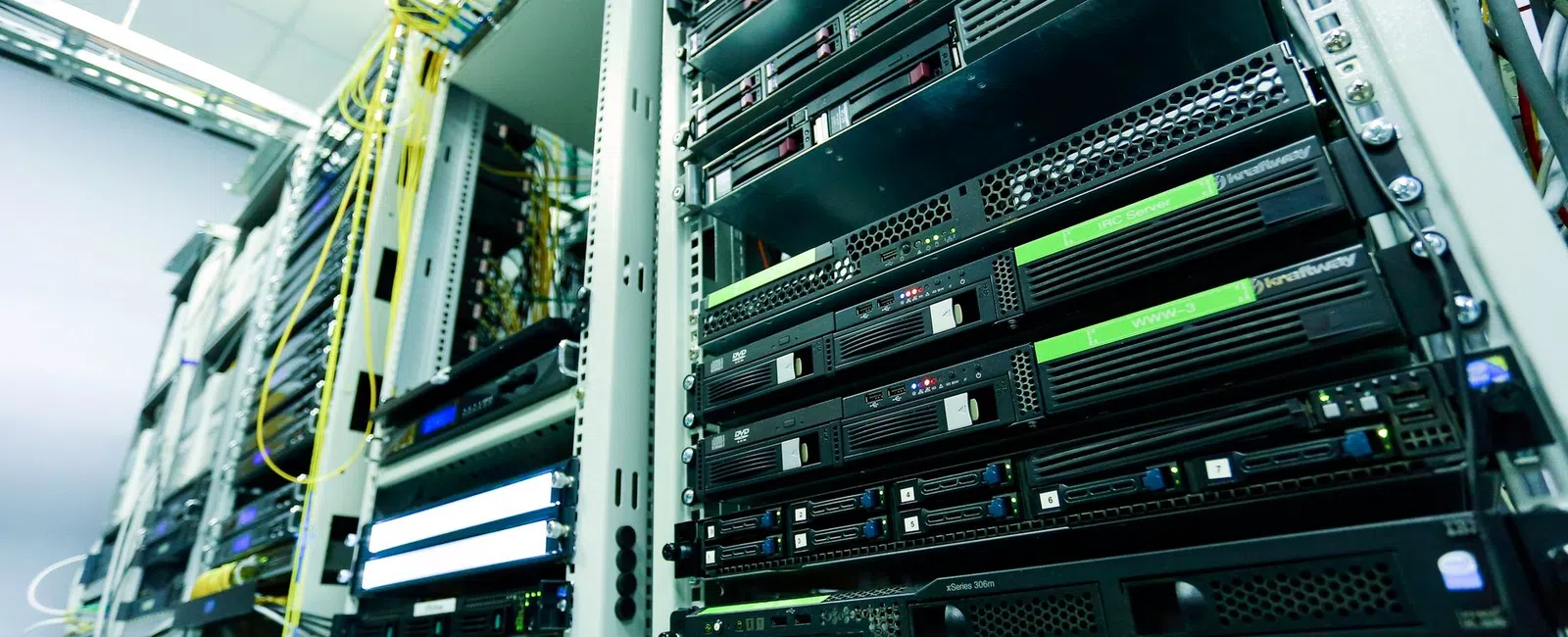 Close-up of server racks with network cables in a data center environment focused on hardware and connectivity.