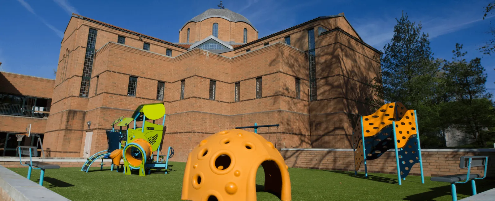 a large building with a lawn and playground equipment in front of it