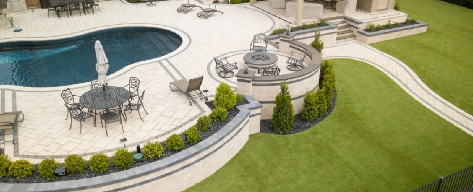 Luxurious backyard with a swimming pool, patio dining area, fire pit seating, and covered outdoor lounge.