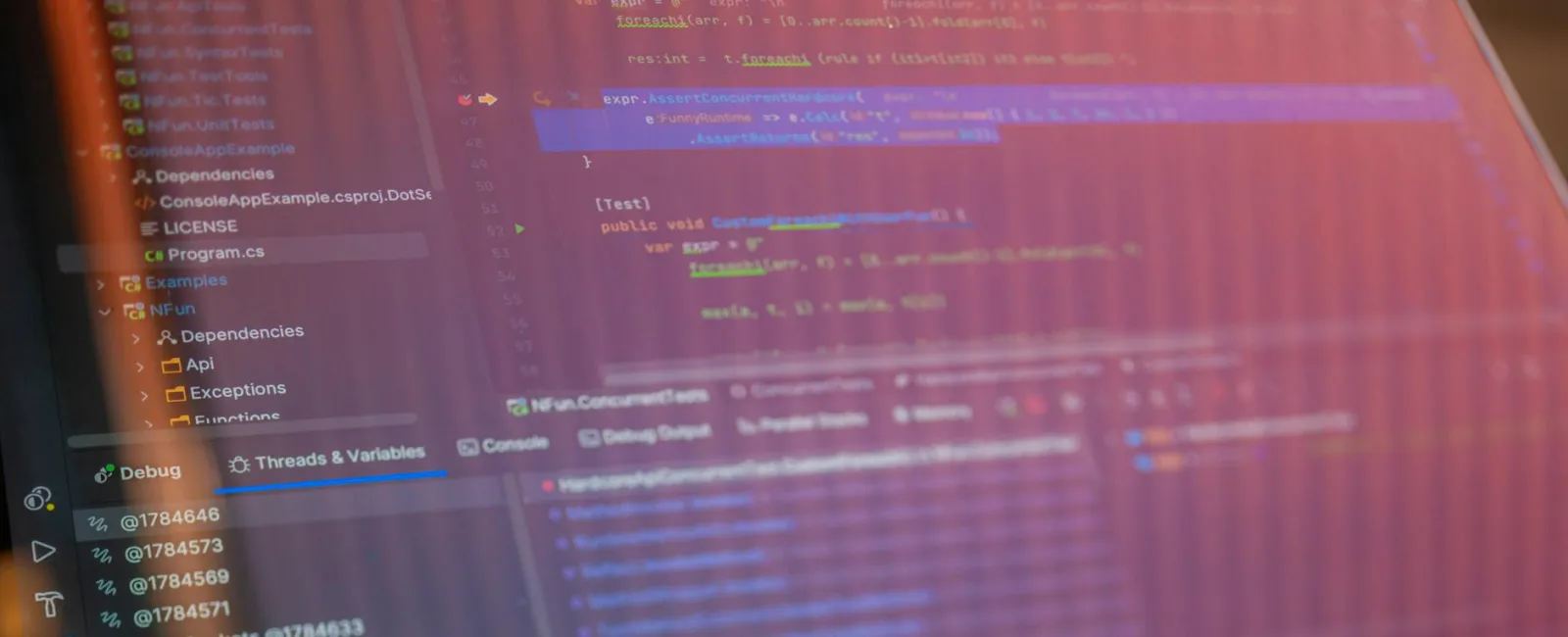 Laptop screen displaying colorful programming code and debugging interface with folder structure and variables panel.