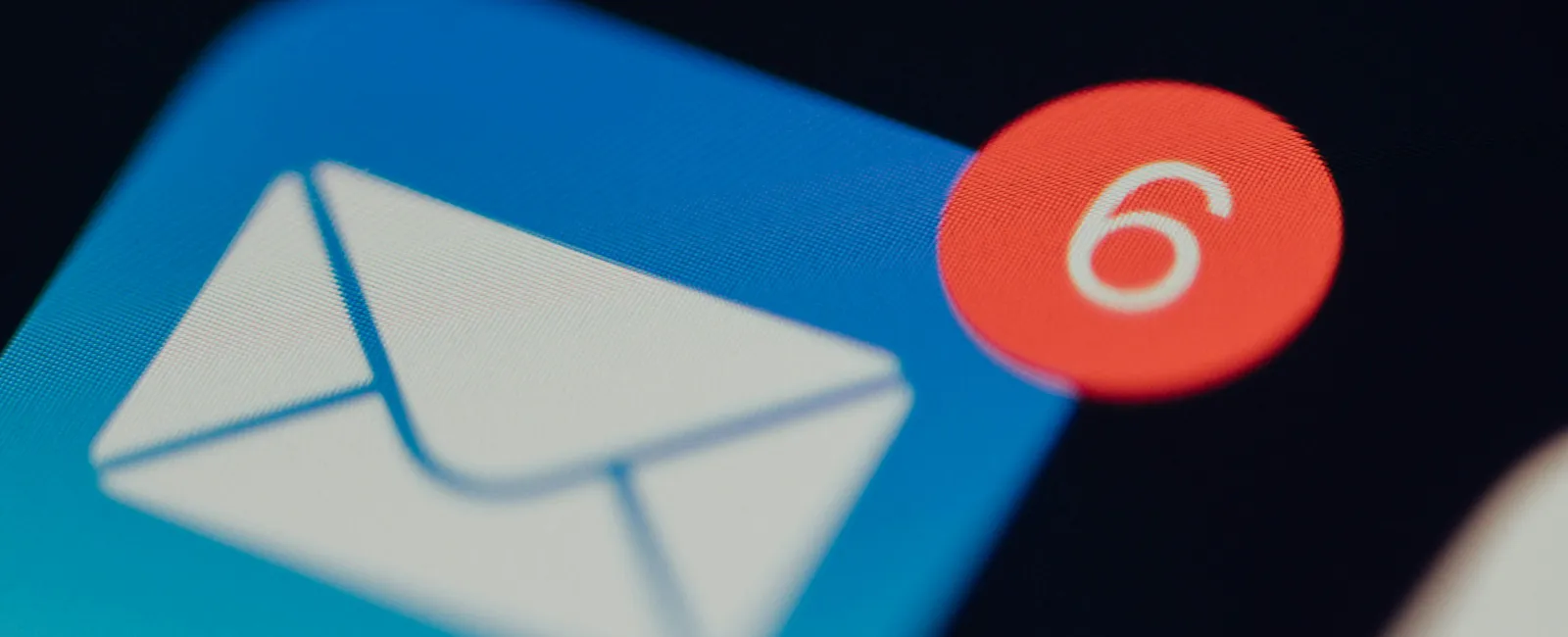 Close-up of a mobile email app icon with a red notification badge showing six unread messages