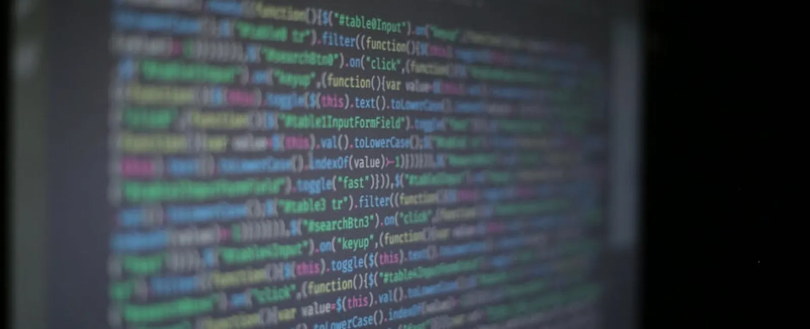 Blurred colorful programming code displayed on a dark screen with various functions and filters.