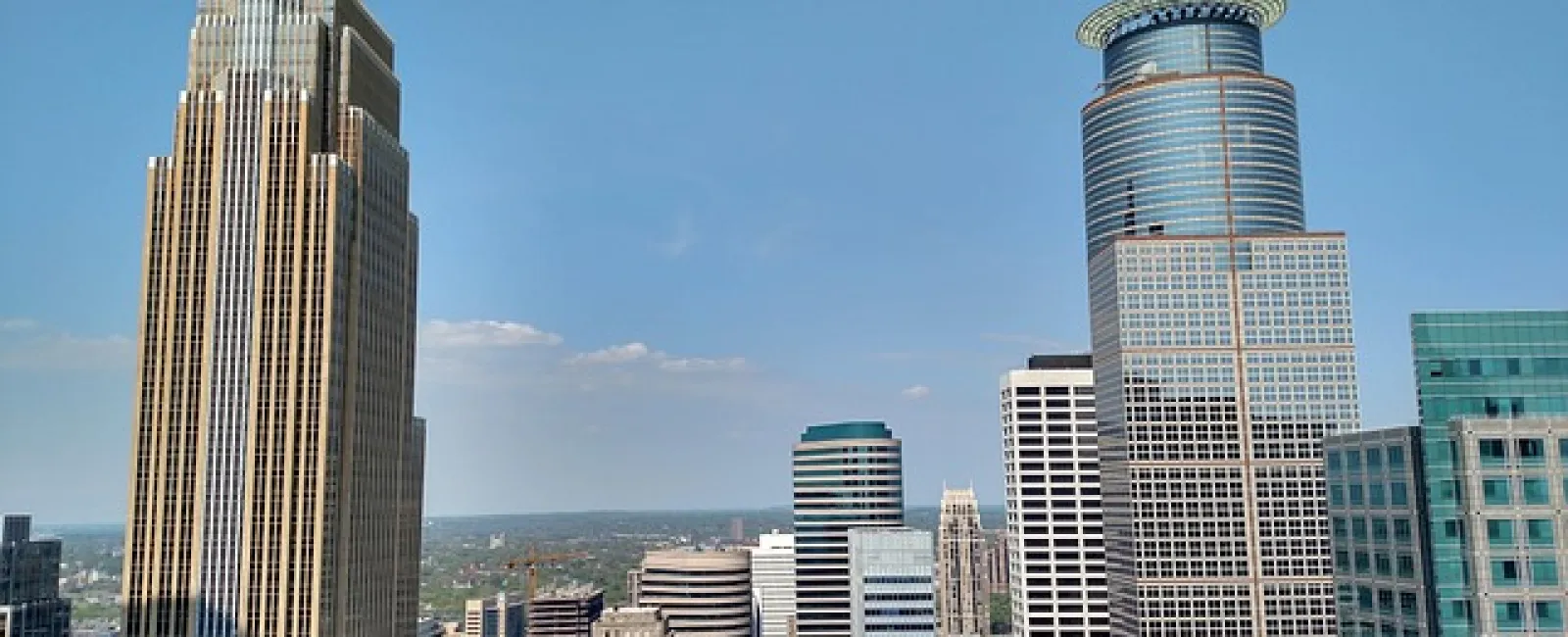 Downtown skyline featuring tall modern skyscrapers under a clear blue sky in a major city