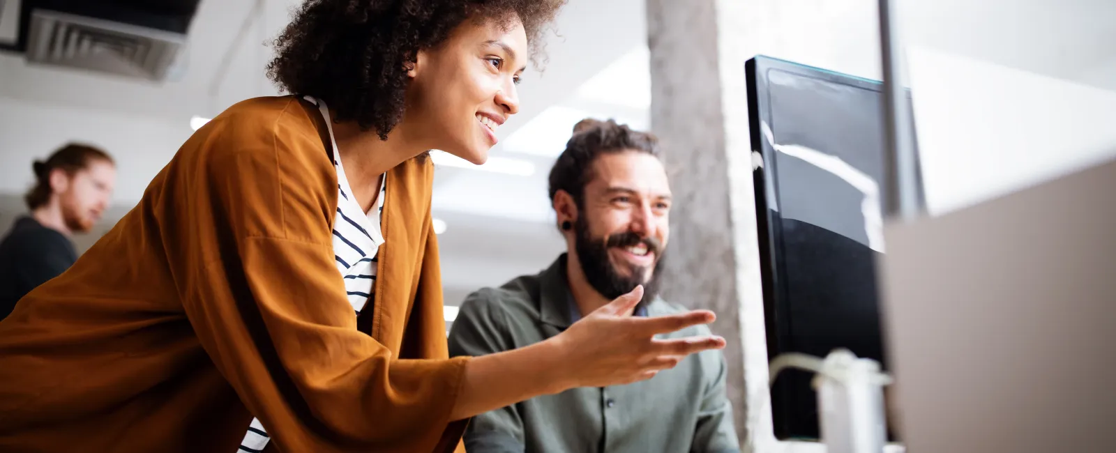 a woman and a man looking at a computer screen