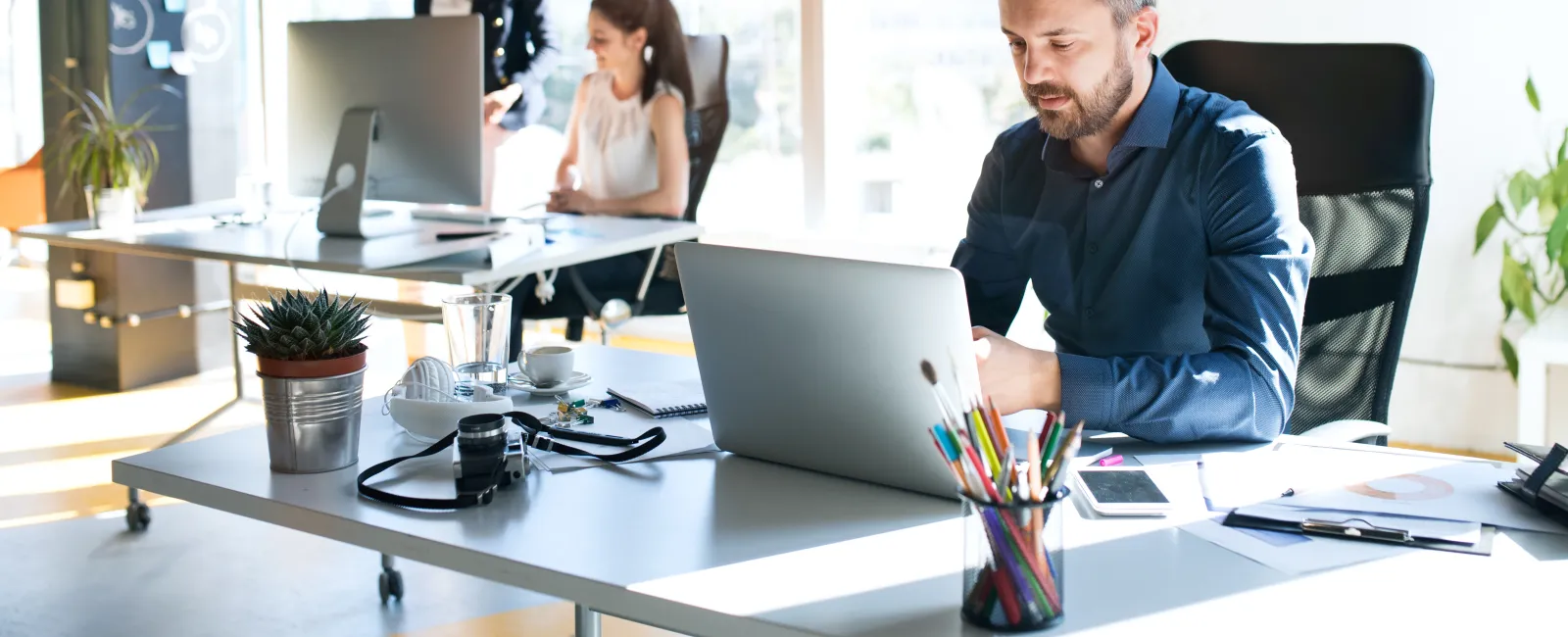 a man and woman sitting at a table with computers