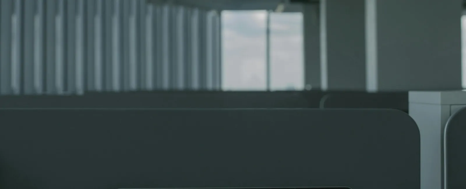 Laptop on office desk displaying the words CYBER SECURITY in red on black screen in a modern workspace.