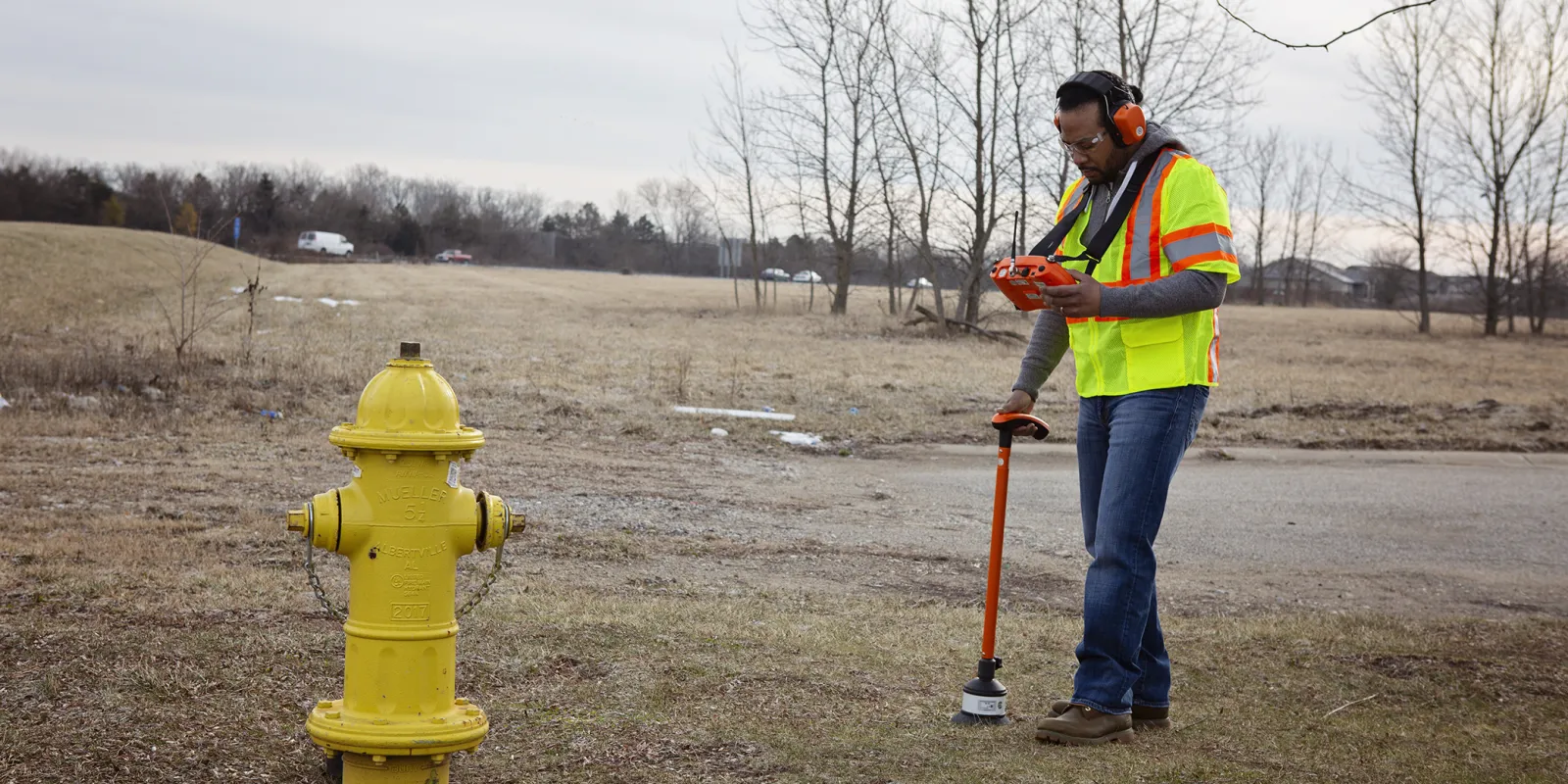 Man near fire hydrant performing underground utility location services for a leak survey or water audit