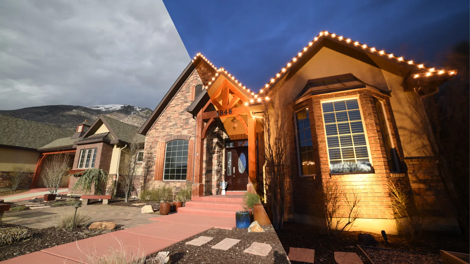 Half day and half night view of a stone and brick house with lit roofline and mountain backdrop.