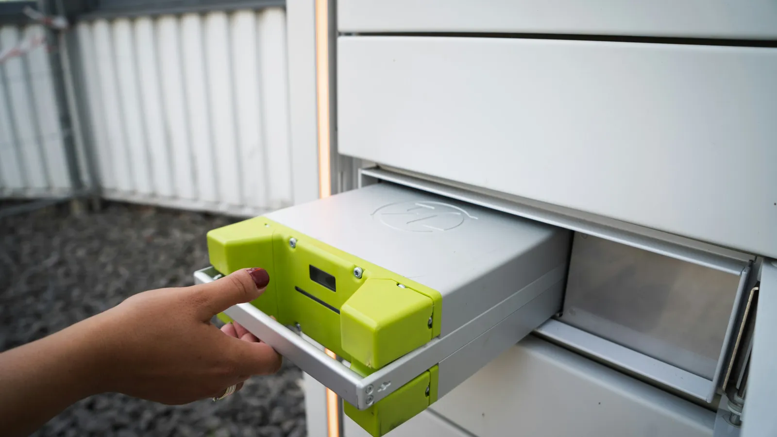 a hand holding a yellow and green machine