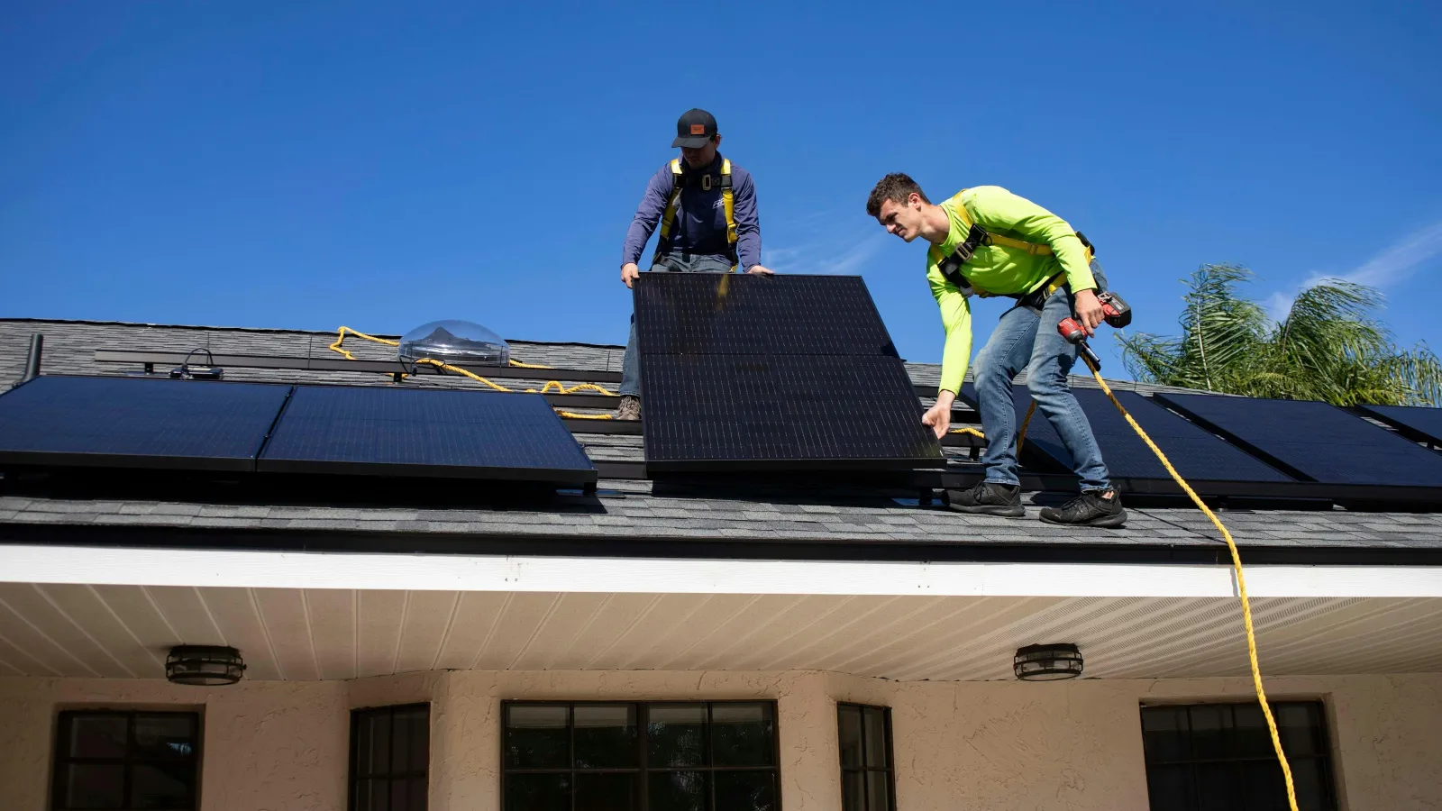 a couple of men on top of a roof
