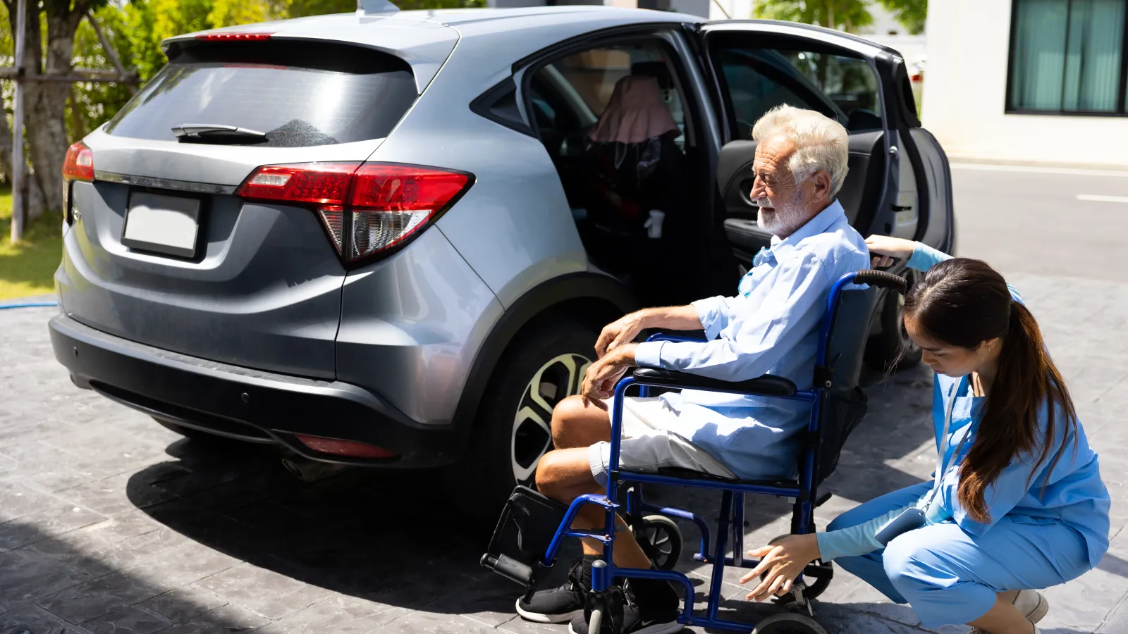 a woman and a man in a wheelchair by a car