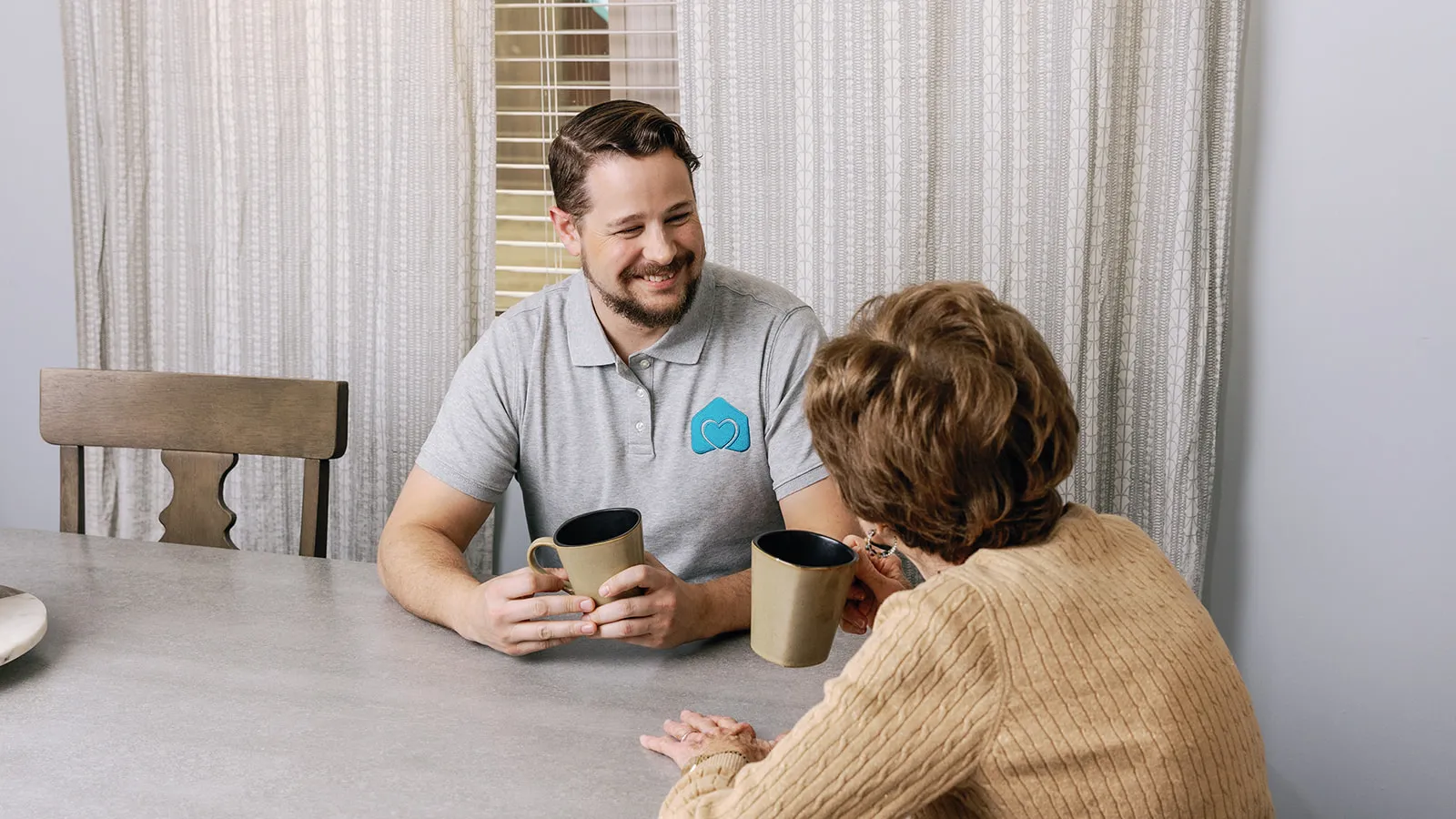 a man and a woman sitting at a table with coffee cups