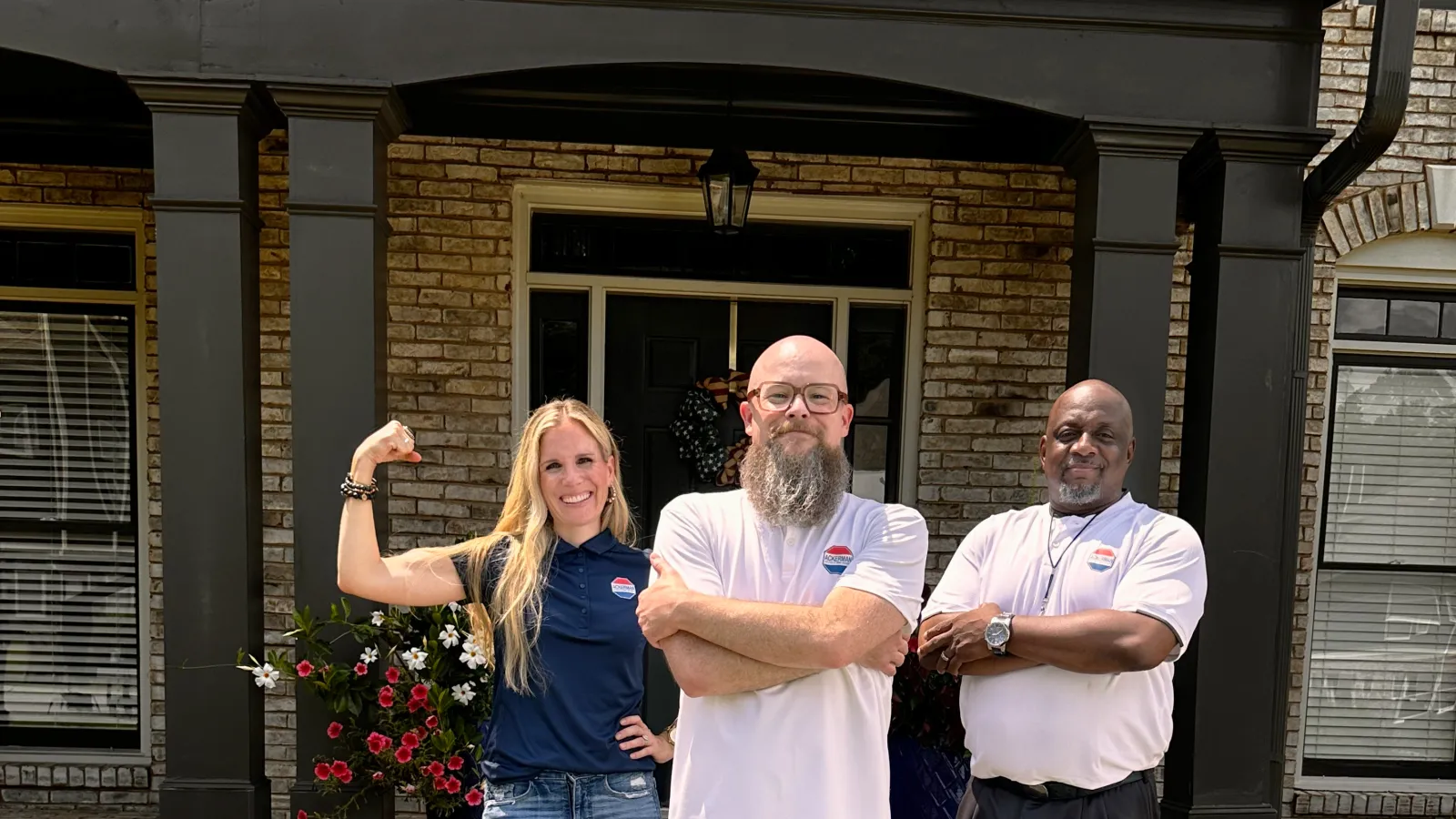 a group of people posing for a photo in front of a house