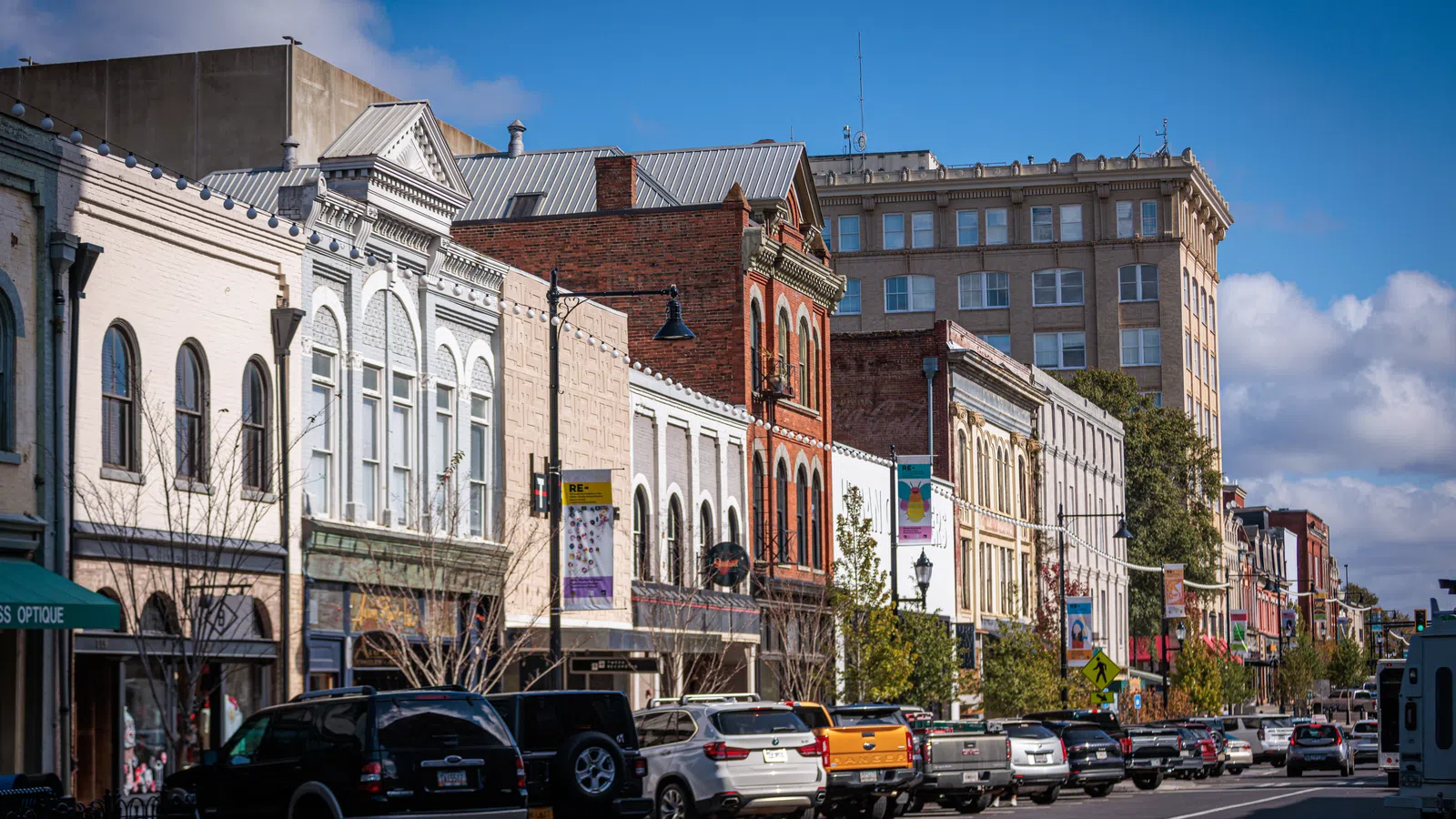 Historic downtown street with vintage buildings, parked cars, and clear blue sky on a sunny day