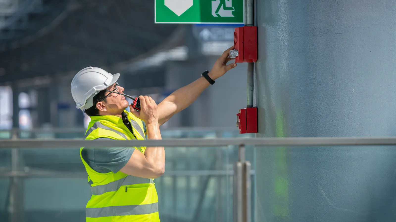 a person wearing a safety vest and holding a red box