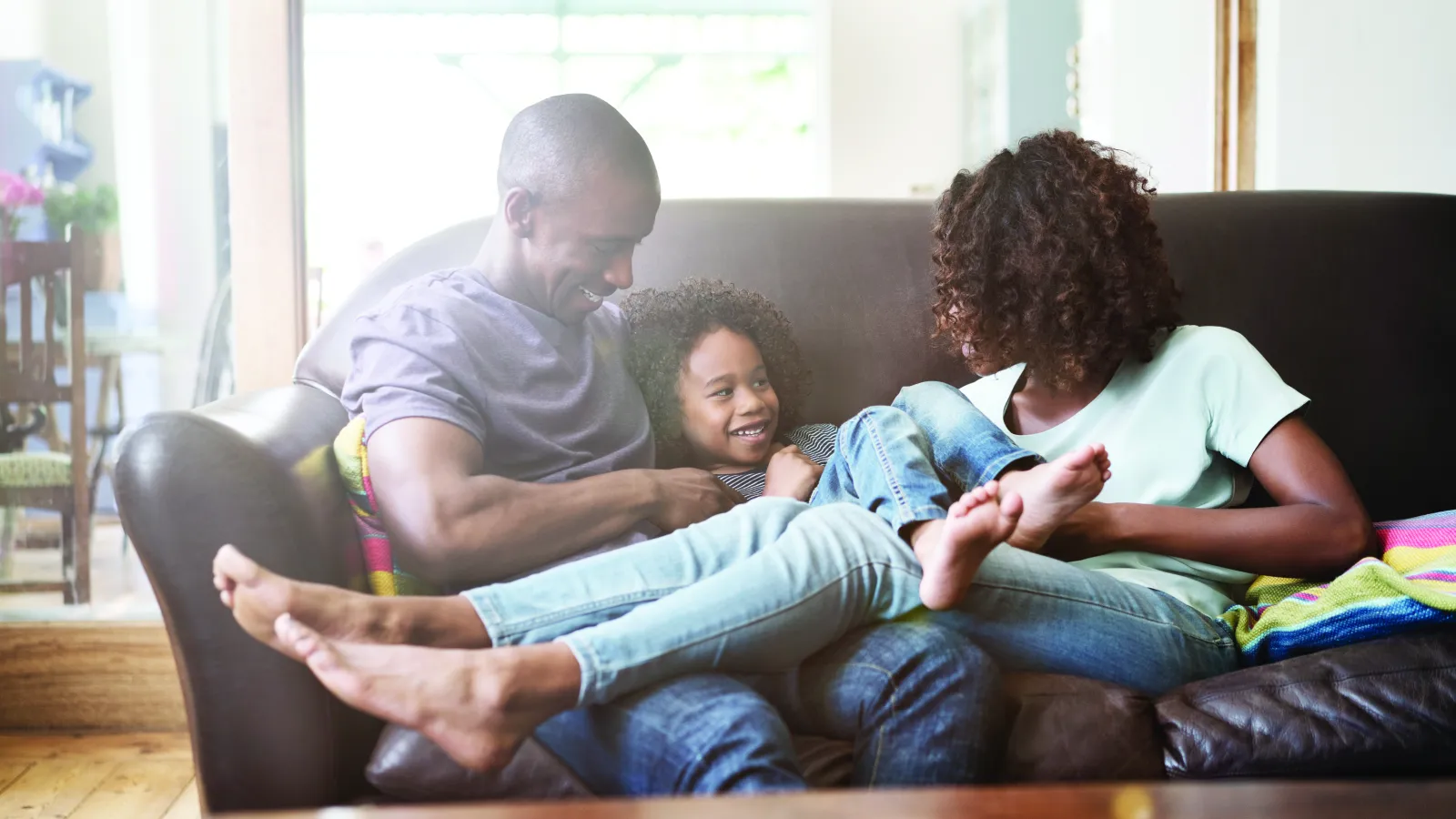 a man and woman sitting on a couch with a child