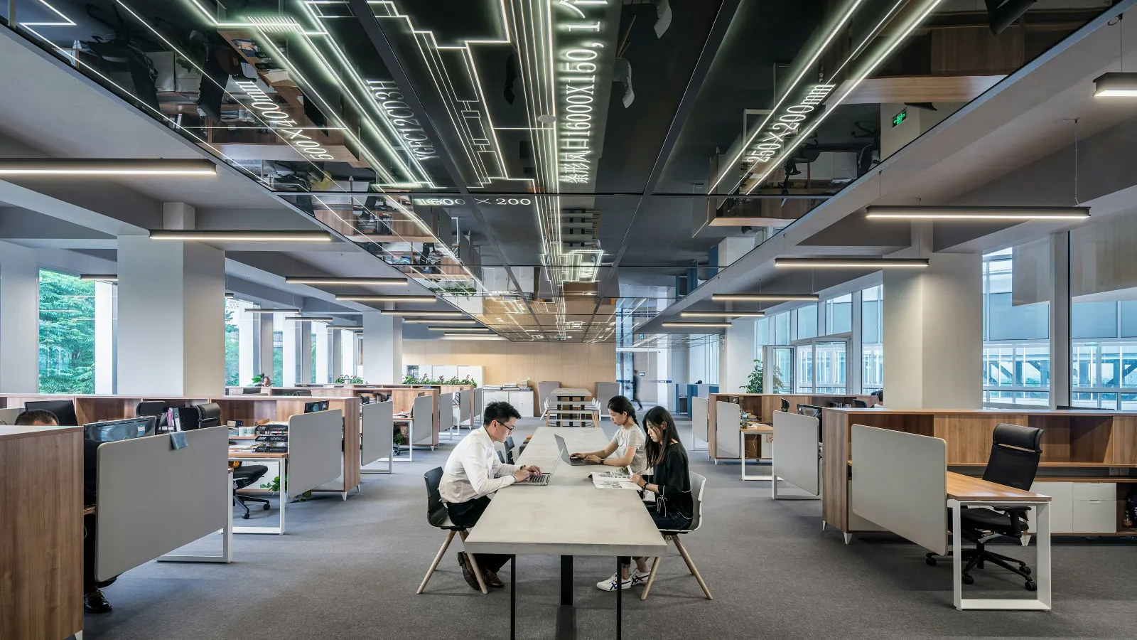 a group of people sitting at a table in a large office