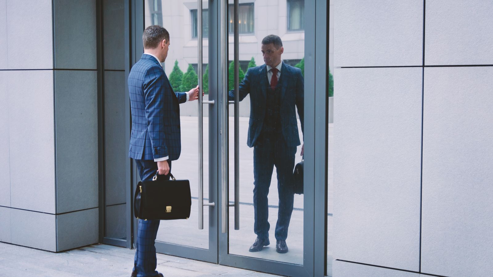 men in suits standing in a doorway