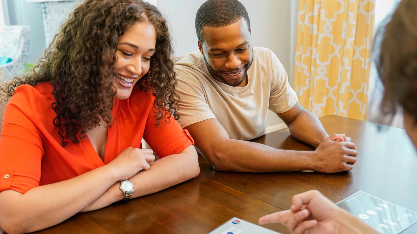 a family sitting at a table and looking at a paper