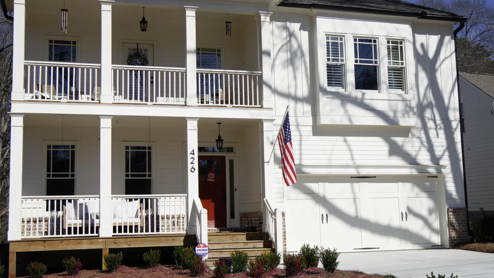 a white house with a flag on the porch