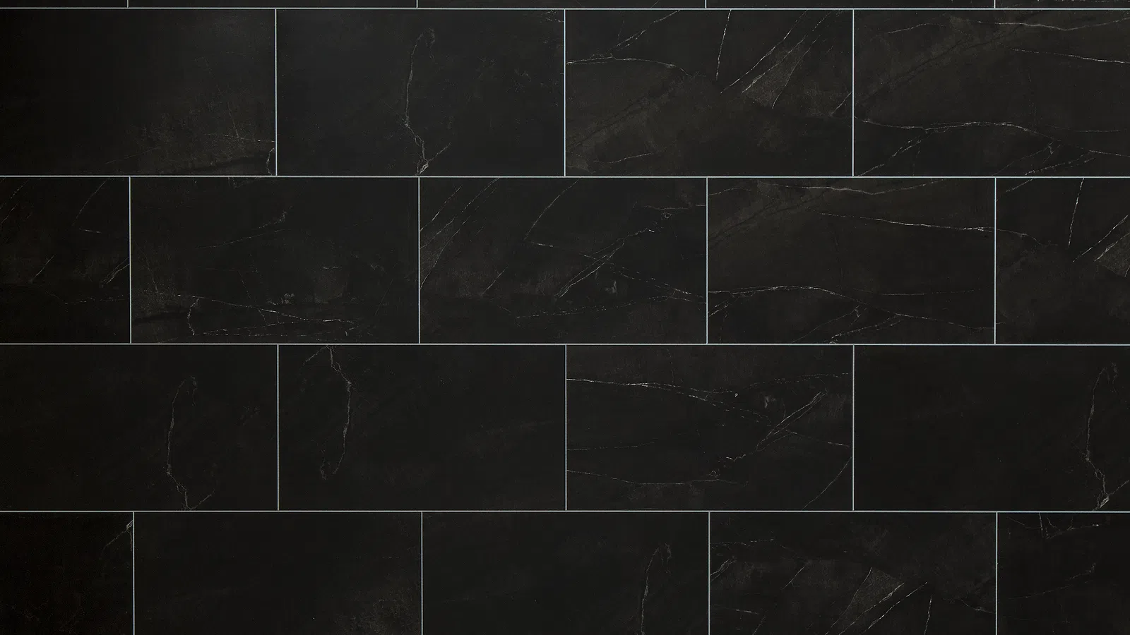 Dark black rectangular tiles with subtle white veining arranged in a staggered brick pattern.