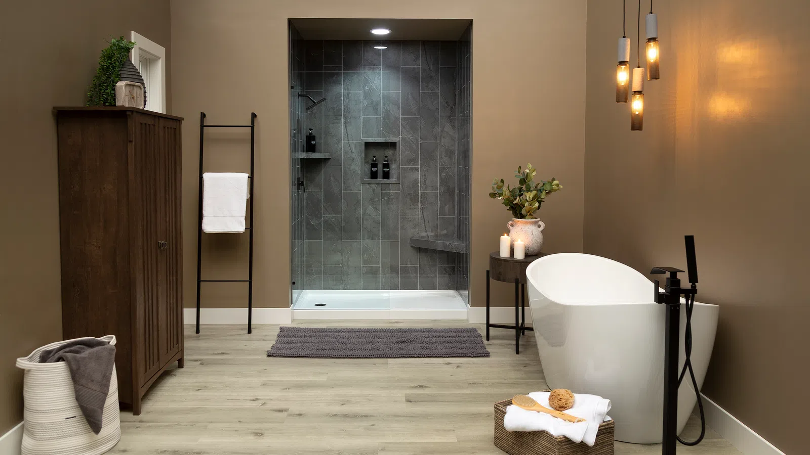 Modern bathroom with freestanding tub, walk-in gray tiled shower, wooden cabinet, and cozy decor.