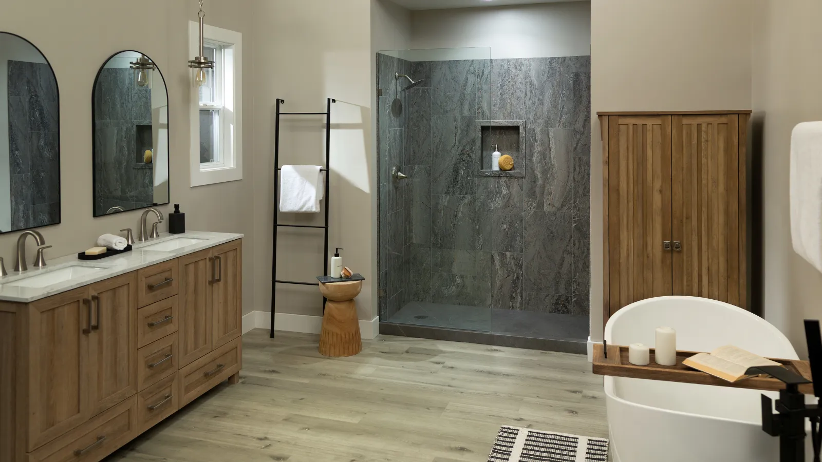 Modern bathroom with wood vanity, frameless glass shower, freestanding tub, and wood storage cabinet.