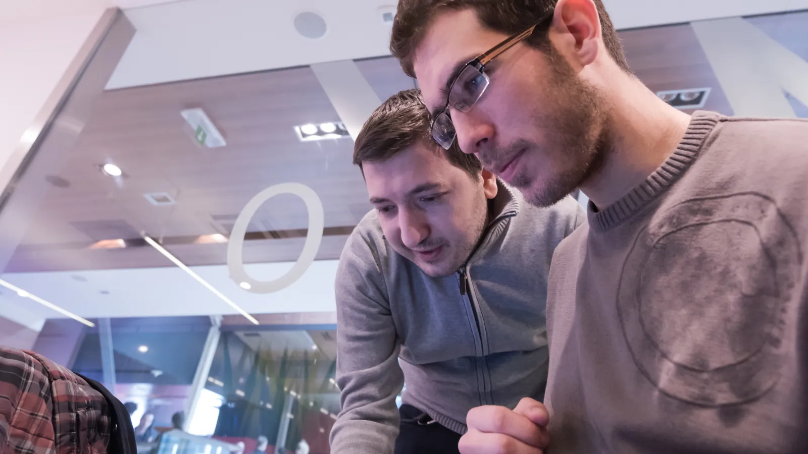 a couple of men looking at a computer screen
