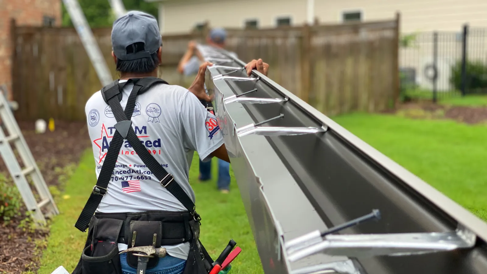 a man carrying gutter to be installed