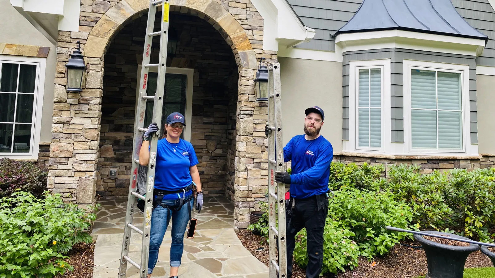 a man and woman standing in front of a house