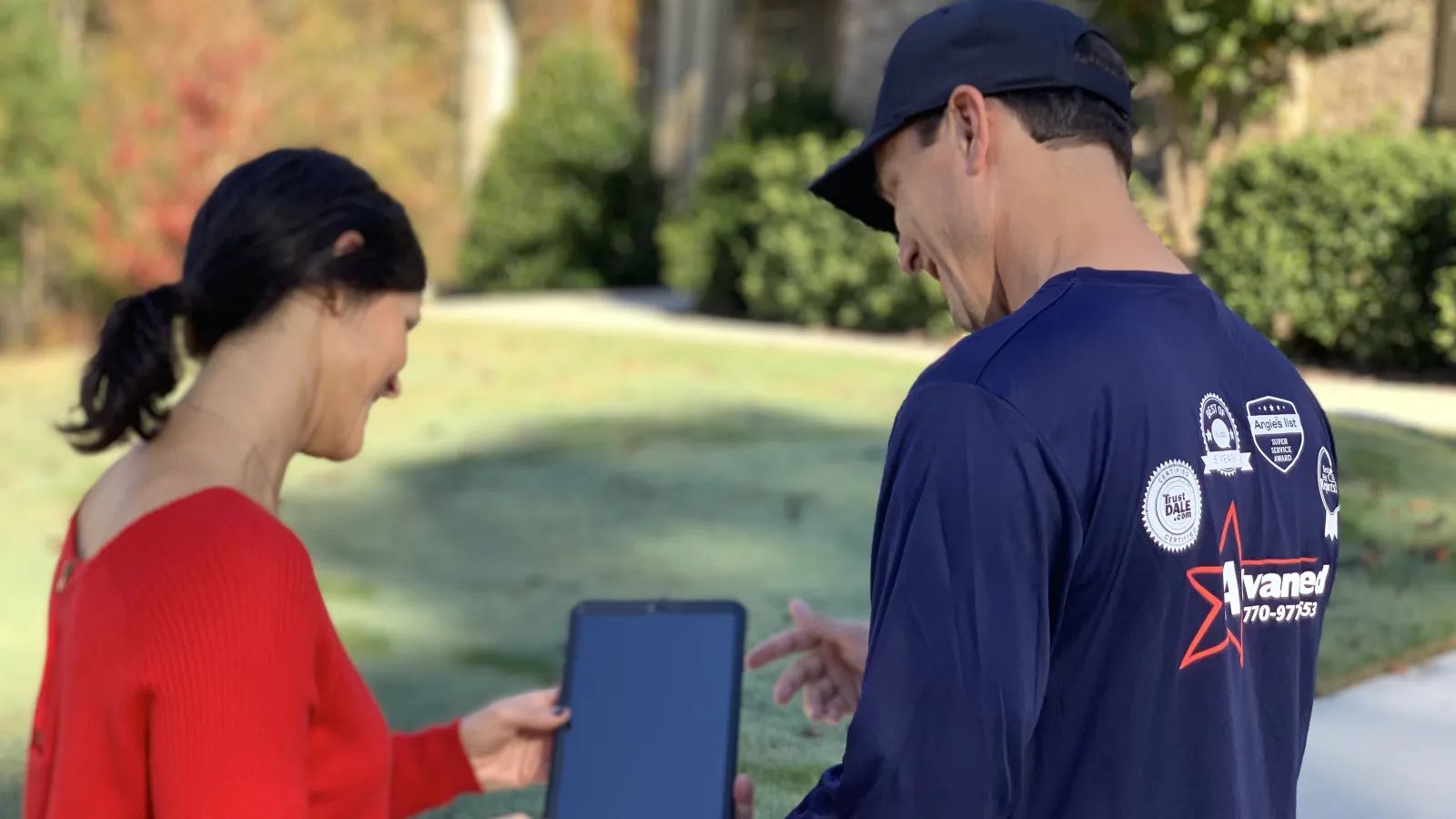 a man and a woman looking at a tablet