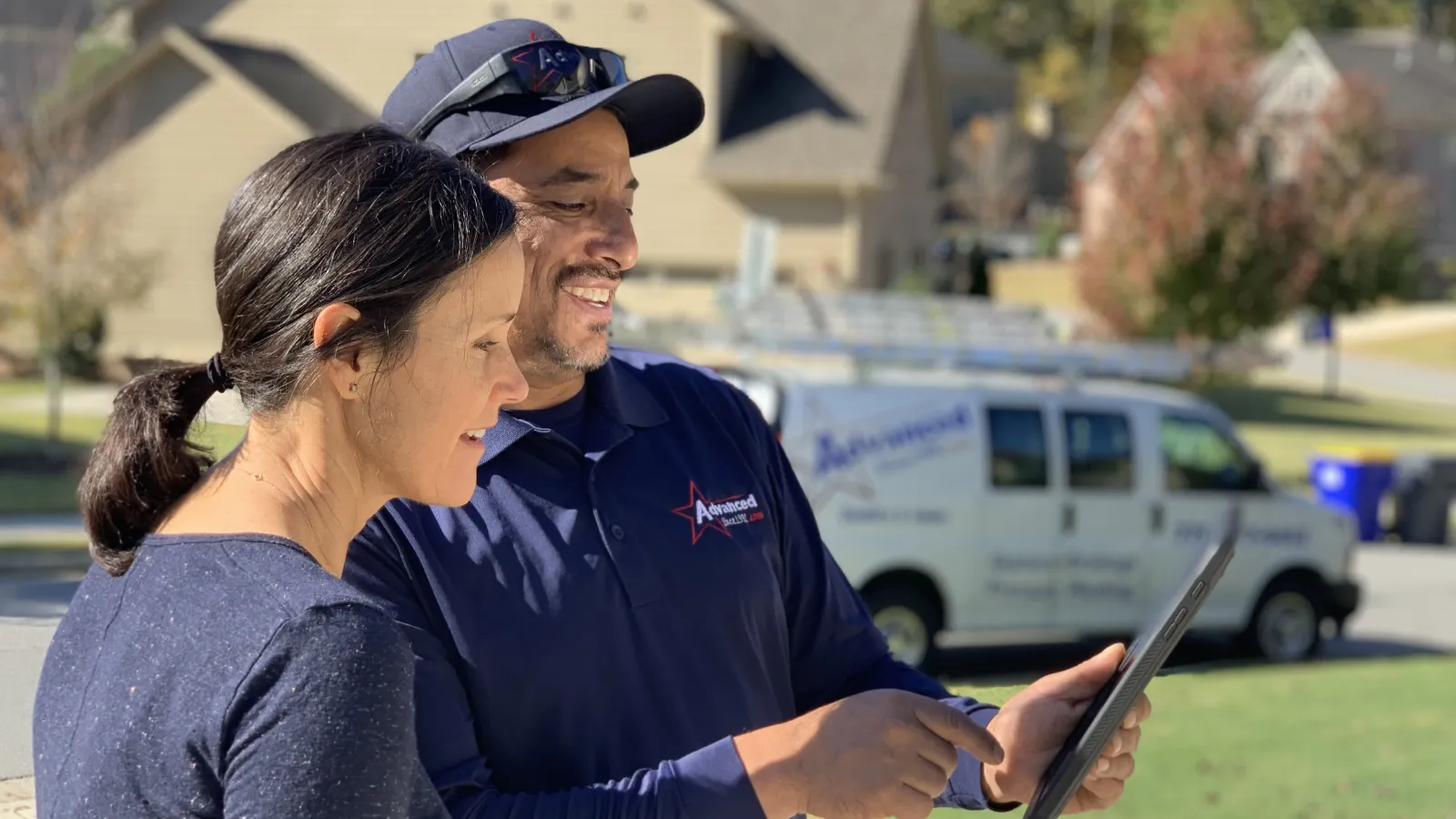 a man and a woman looking at a tablet