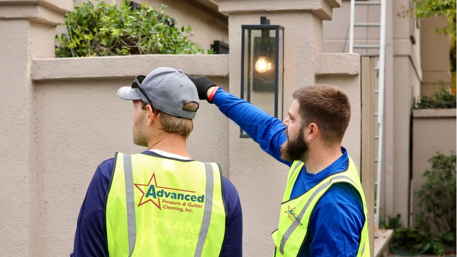 Two commercial gutter cleaners in safety vests in Atlanta, GA