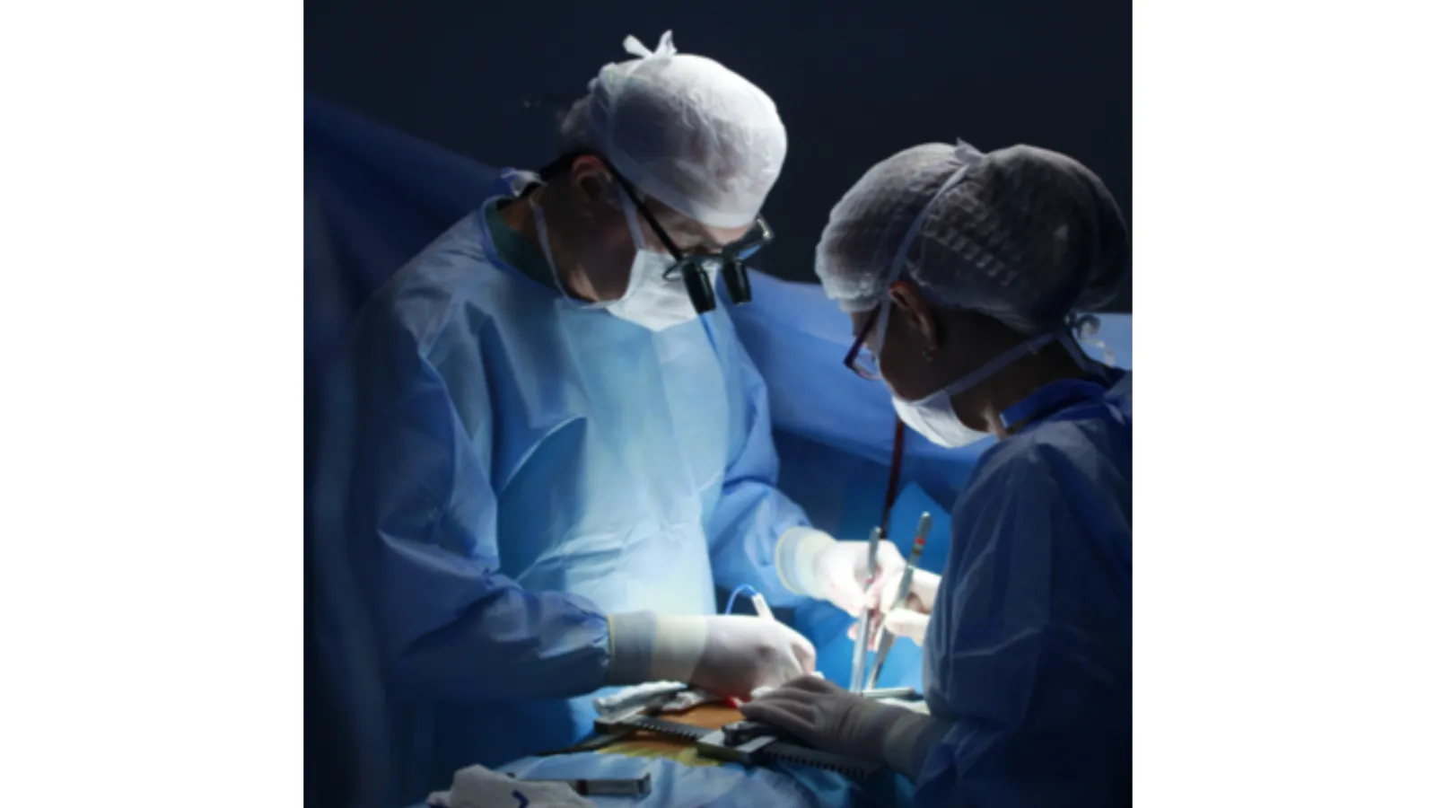 Surgeons performing a delicate operation in a sterile environment with focus and precision.