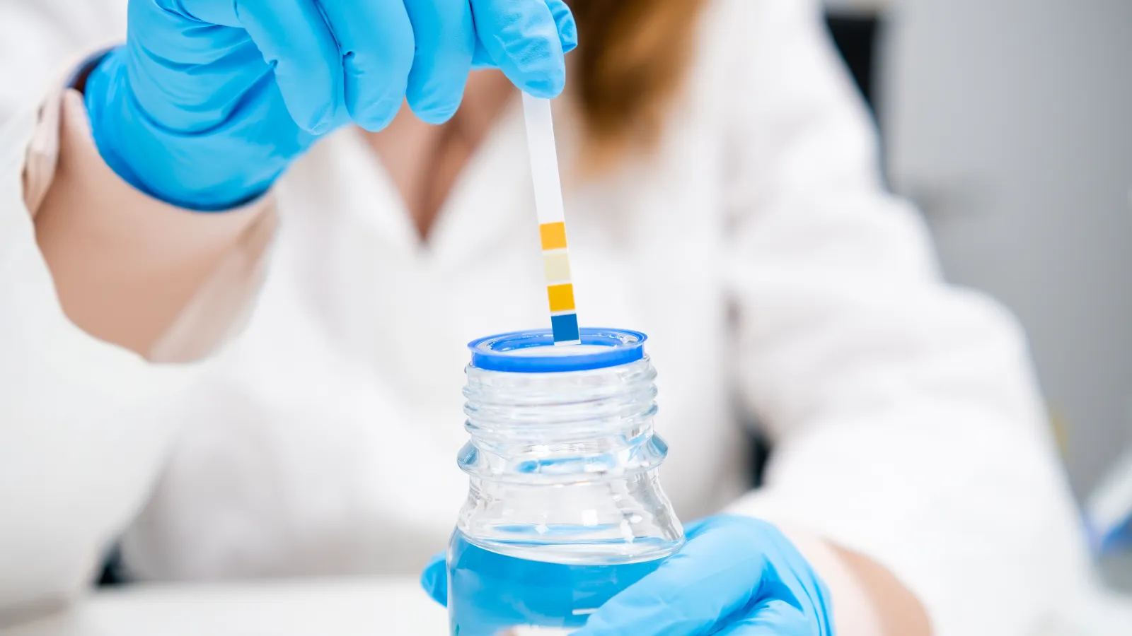 a person in a white lab coat holding a syringe