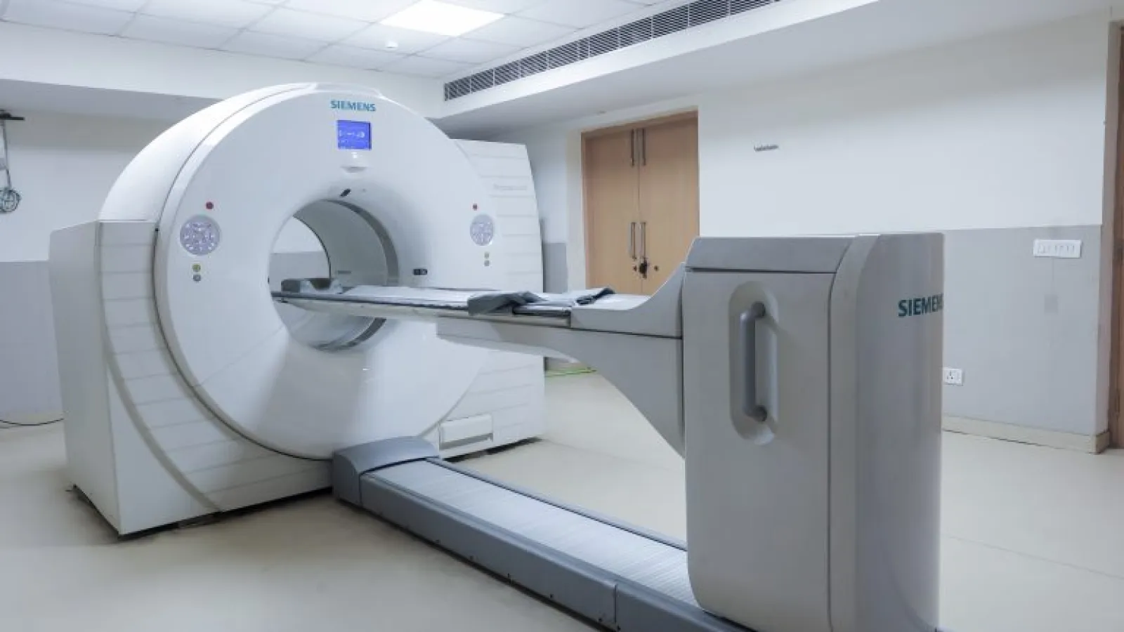 Modern Siemens MRI scanner in a clean, well-lit medical room with white walls and tiled floor.