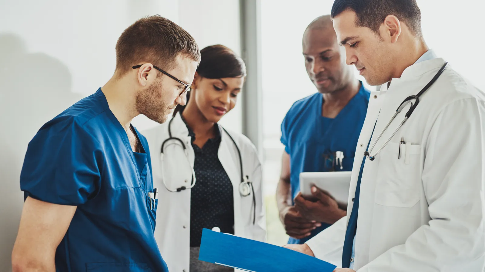 a group of doctors looking at a tablet